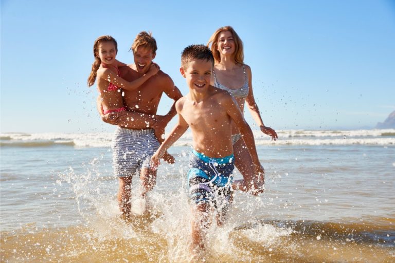 A family running through the surf on a beach